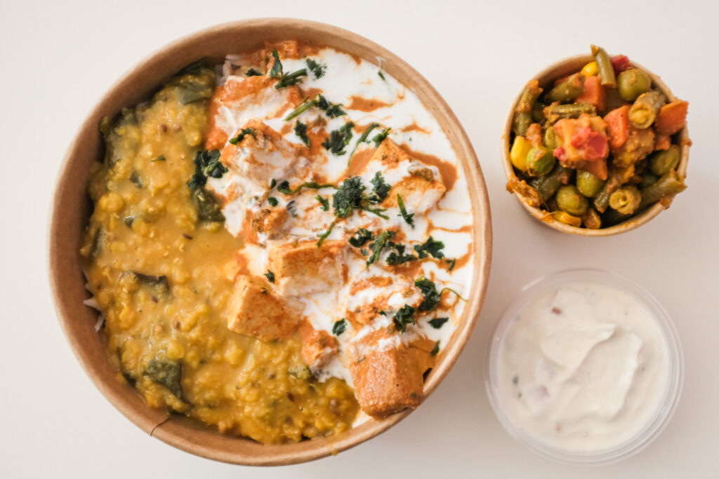 Een rijk gevulde kom met Indiase curry, dal en groenten bij Curry Me
