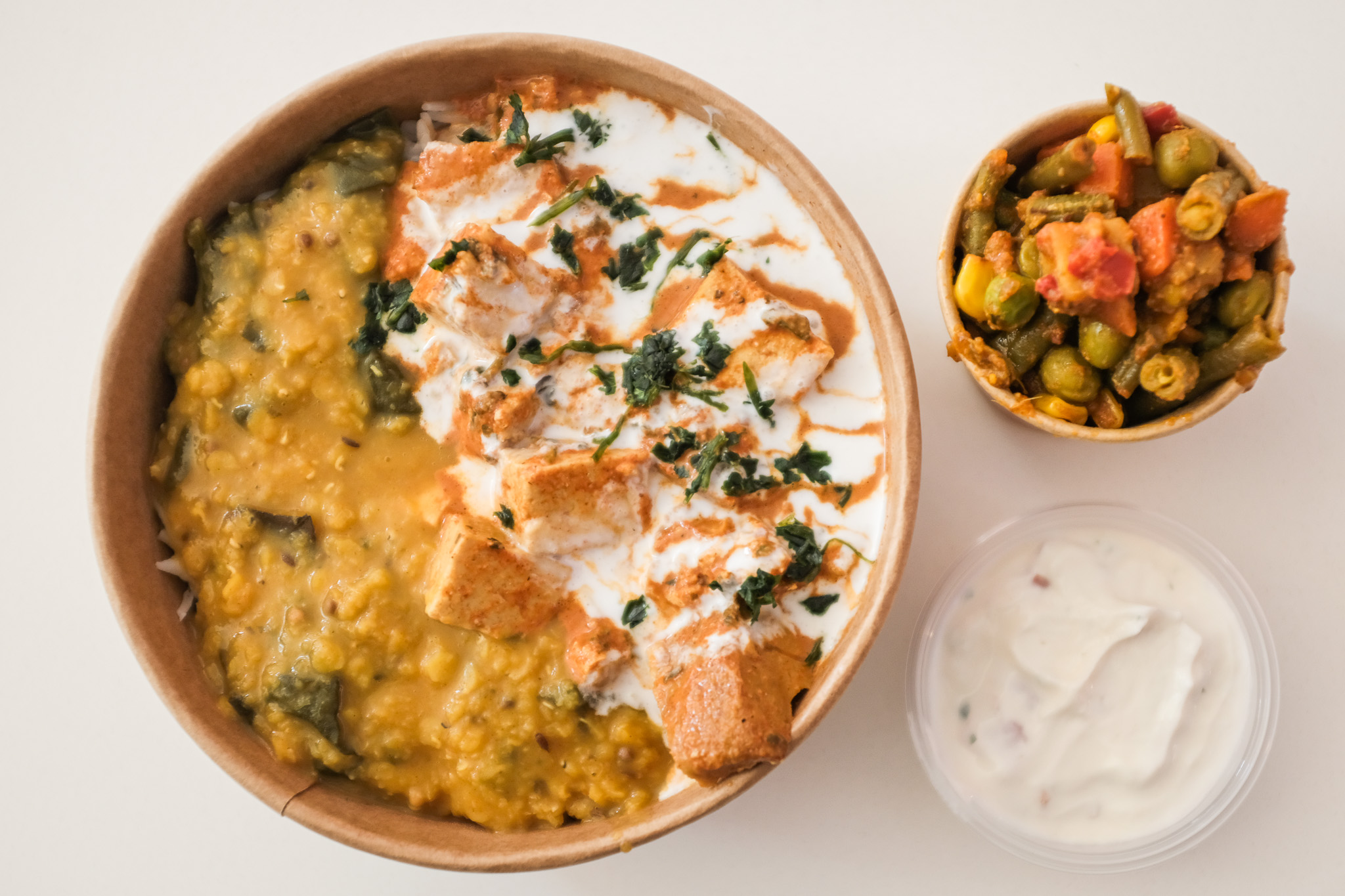 Een kom met verschillende curries, rijst en groenten bij Curry Me