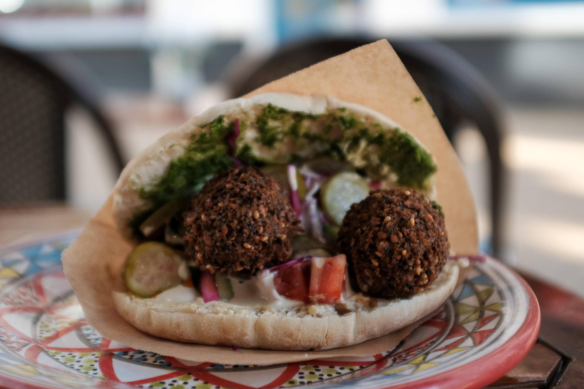 Een versgevulde pita met falafel, groenten, hummus en kruiden bij FLFL