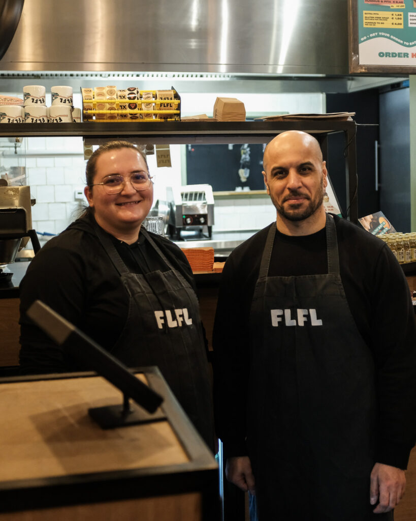 Twee medewerkers van FLFL staan achter de toonbank