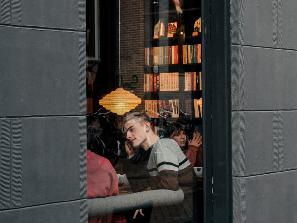 Gasten bij Koffiestation Books & Coffee, gezien door het raam