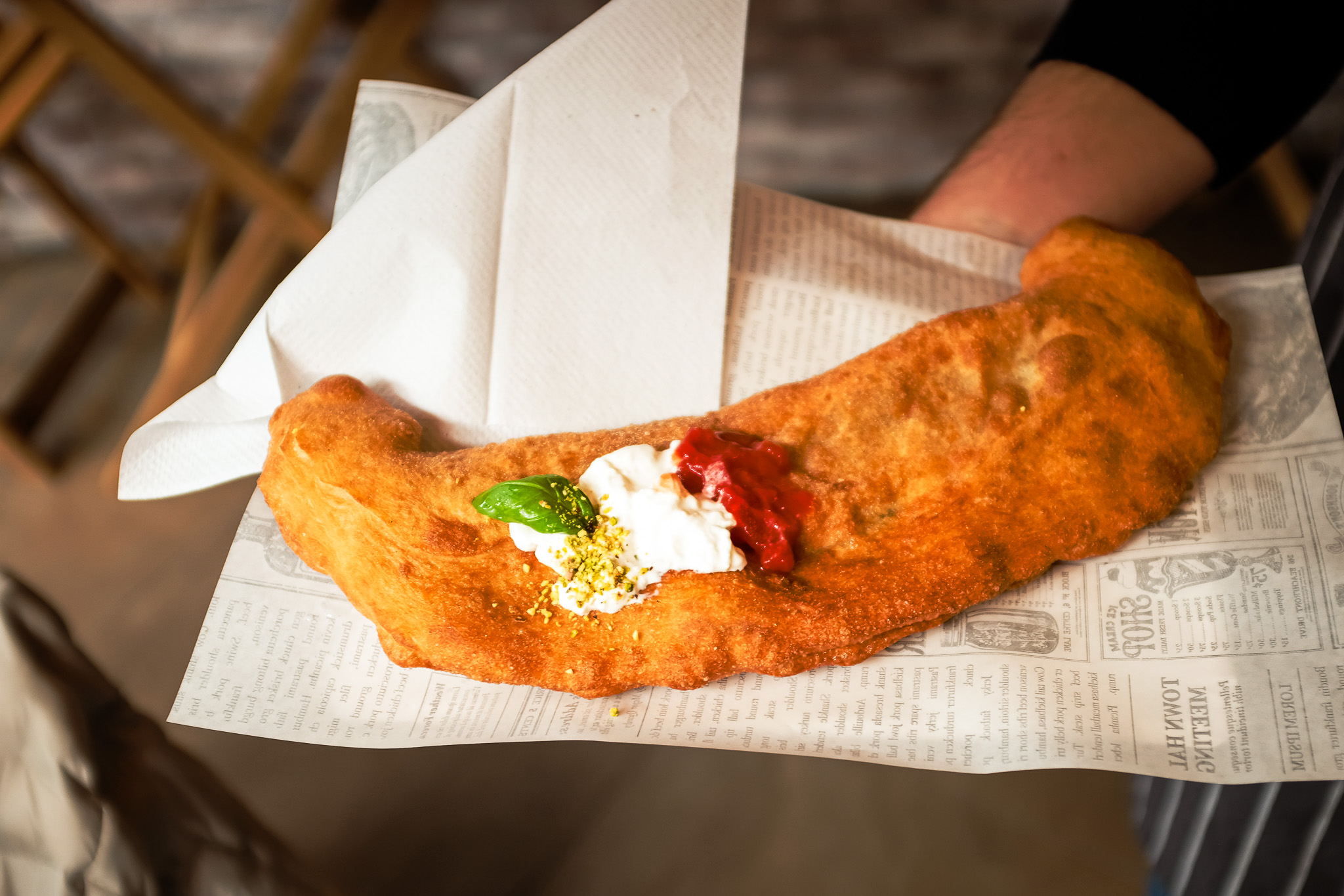 Goudbruine pizza fritta van Little Italy, geserveerd op bedrukt papier