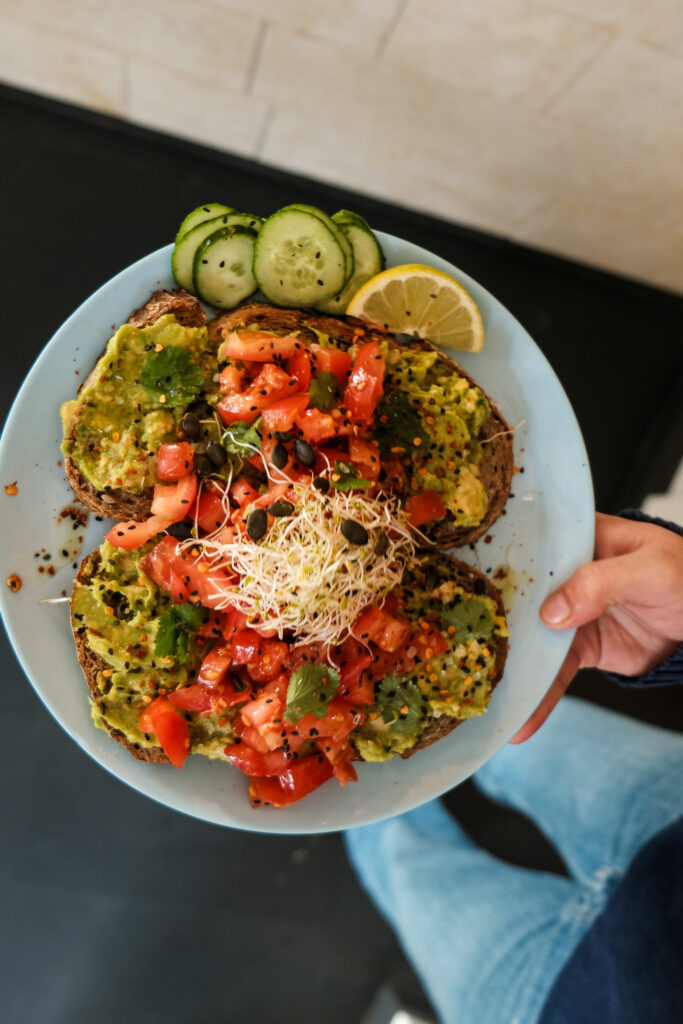 Een kleurrijk bord met plantaardige avocadotoast bij Mahalo