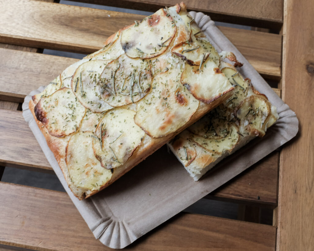Pizza al taglio van Muzzica op een houten tafel