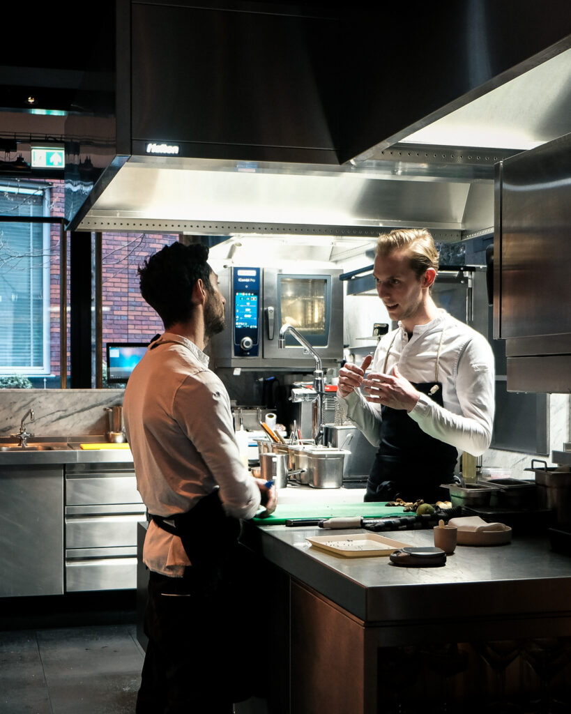 Twee chefs overleggen in de open keuken van Niemeijer