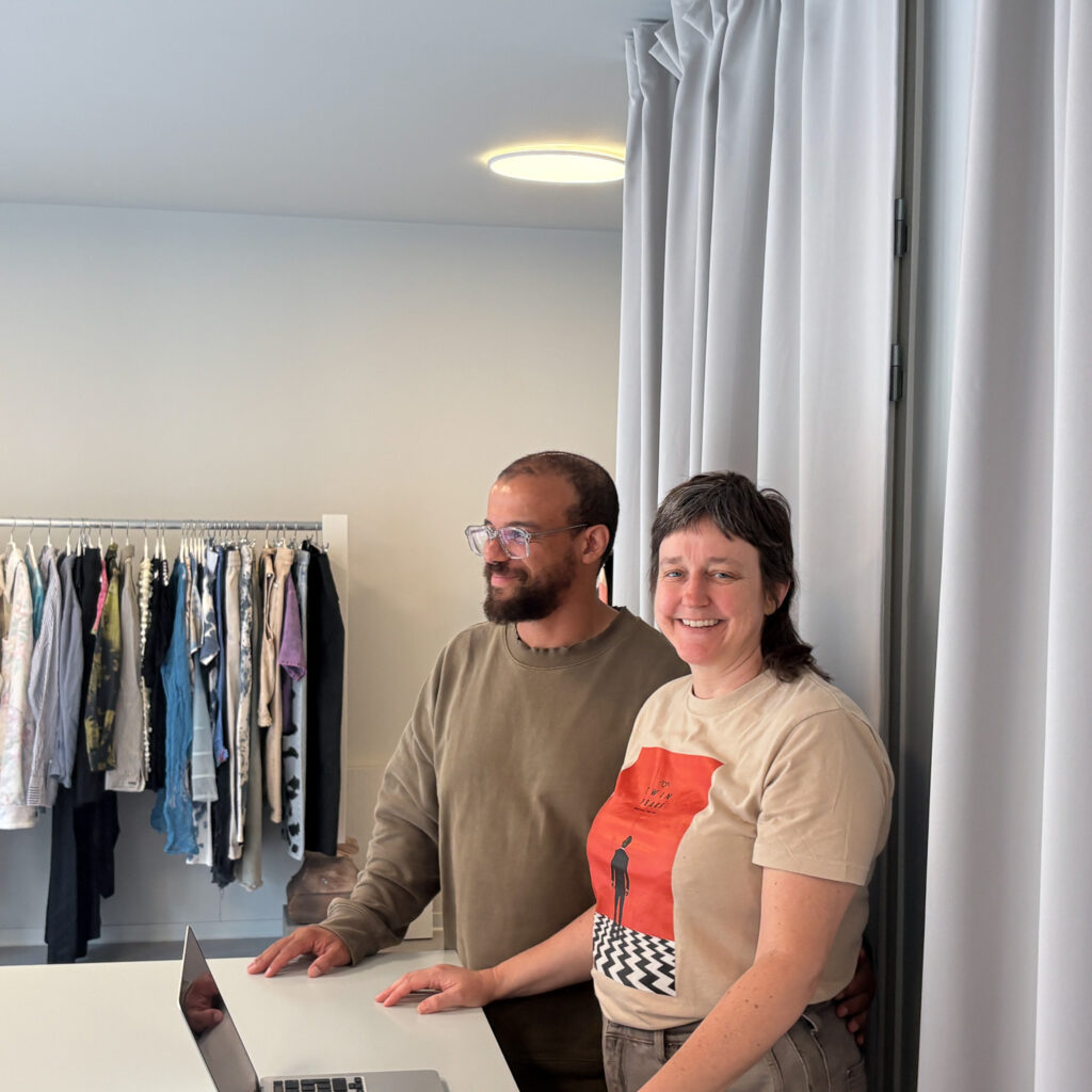 Twee mensen bij de toonbank van YoYo shop, met kledingrekken op de achtergrond