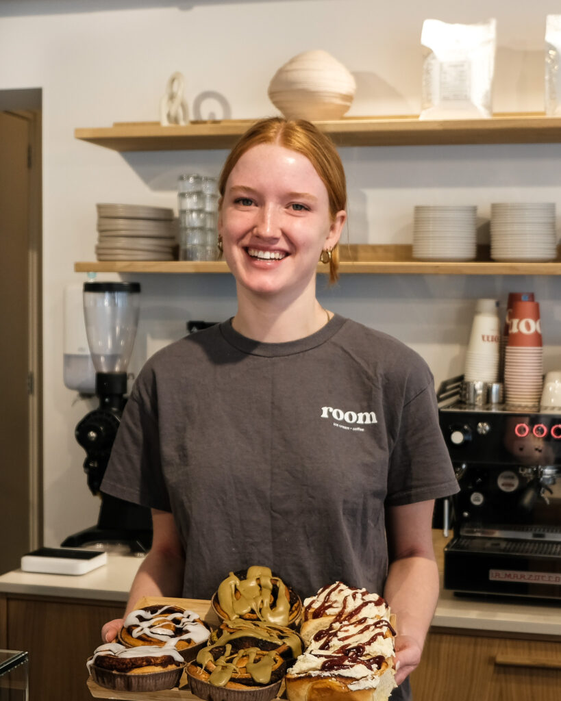 Een medewerker van Room met een schaal vol gebak