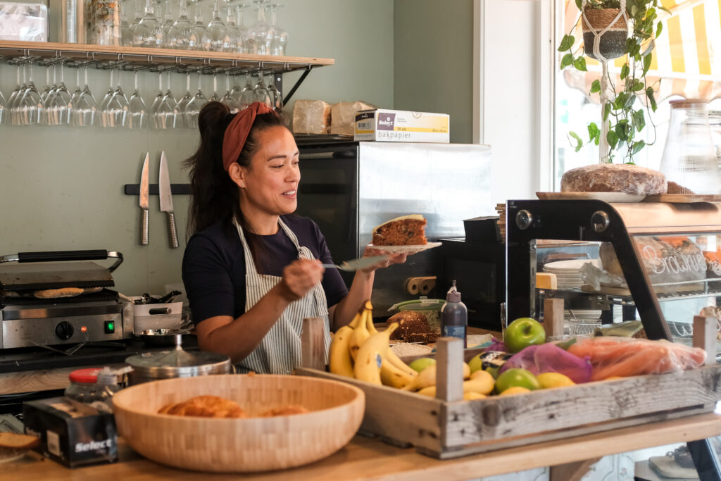 Een medewerker serveert een stuk taart achter de bar van Struis