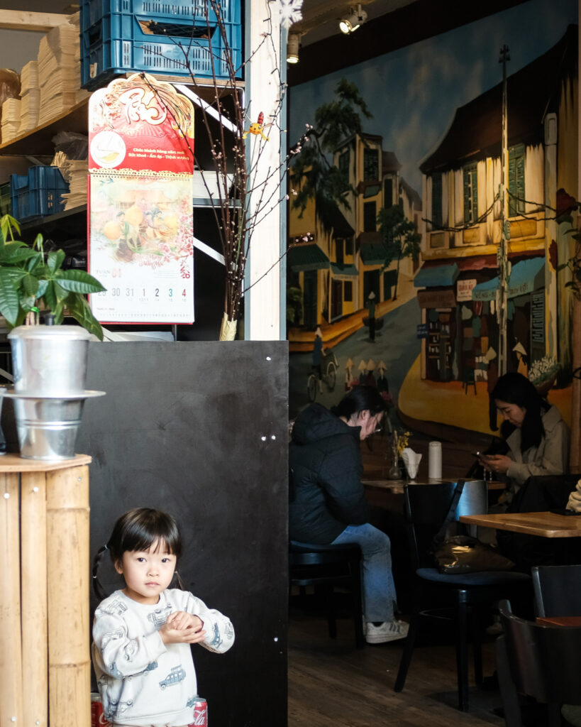 Het warme interieur van Tra Bar met een Vietnamese straatscène op de wand