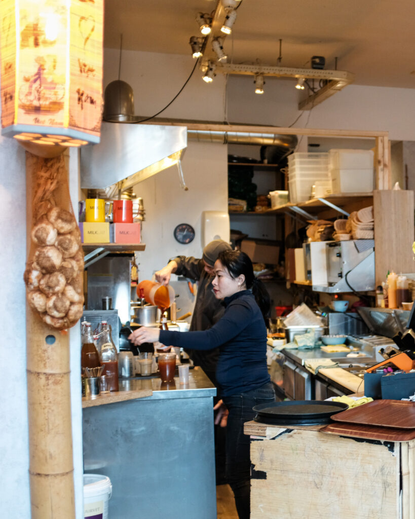 Medewerkers aan het werk in de open keuken van Tra Bar
