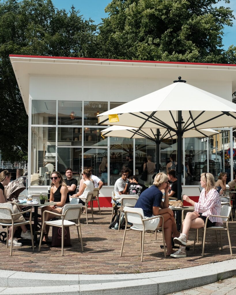 Het zonnige terras van Van Deeg Vandaag voor het gerestaureerde Dudok-tankstation