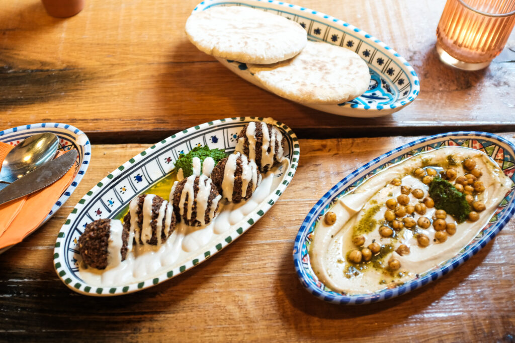 Een kleurrijke tafel vol falafel, hummus en groenten bij FLFL